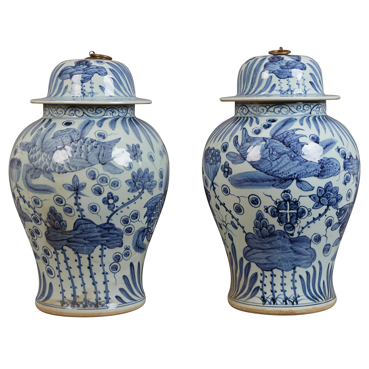 A pair of contemporary blue and white Chinese-style lidded jars, decorated with carp