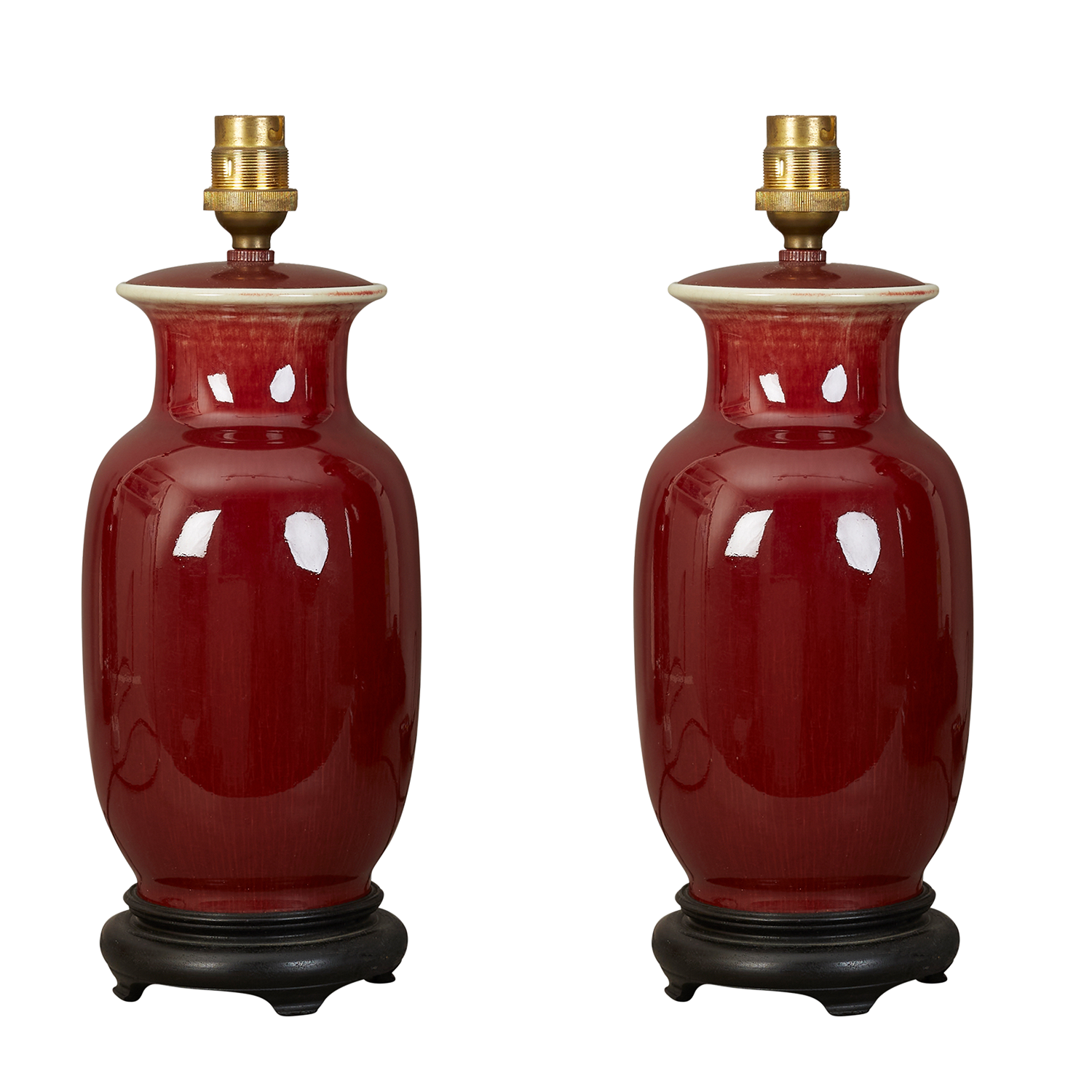 A pair of small Sang de boeuf glazed ceramic table lamp on ebonised stands