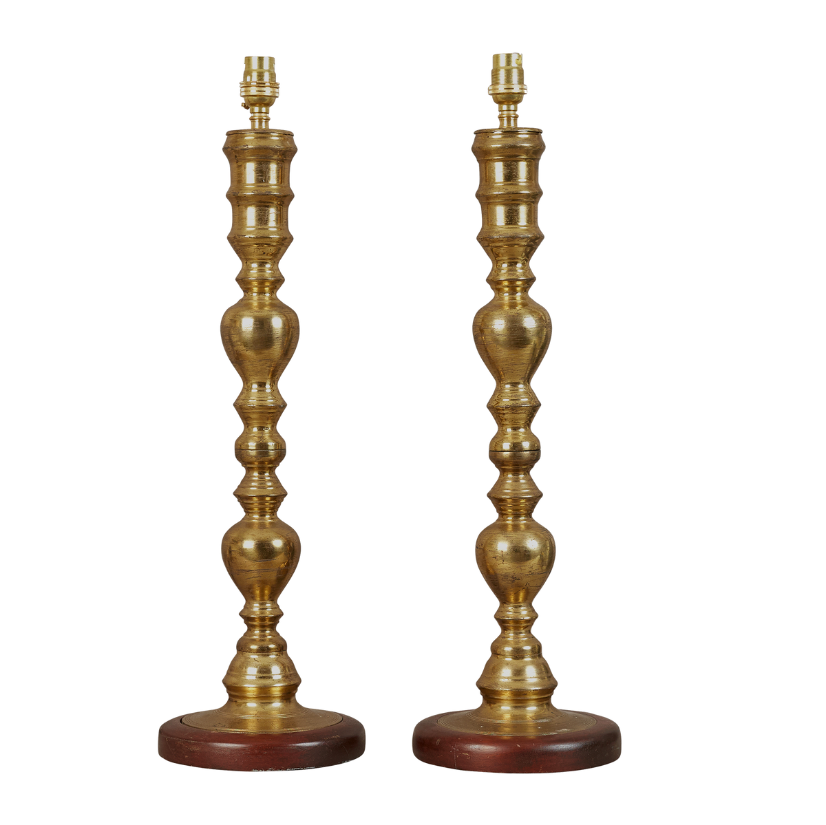 A pair of early 20th century brass turned lamps on mahogany bases, electrified