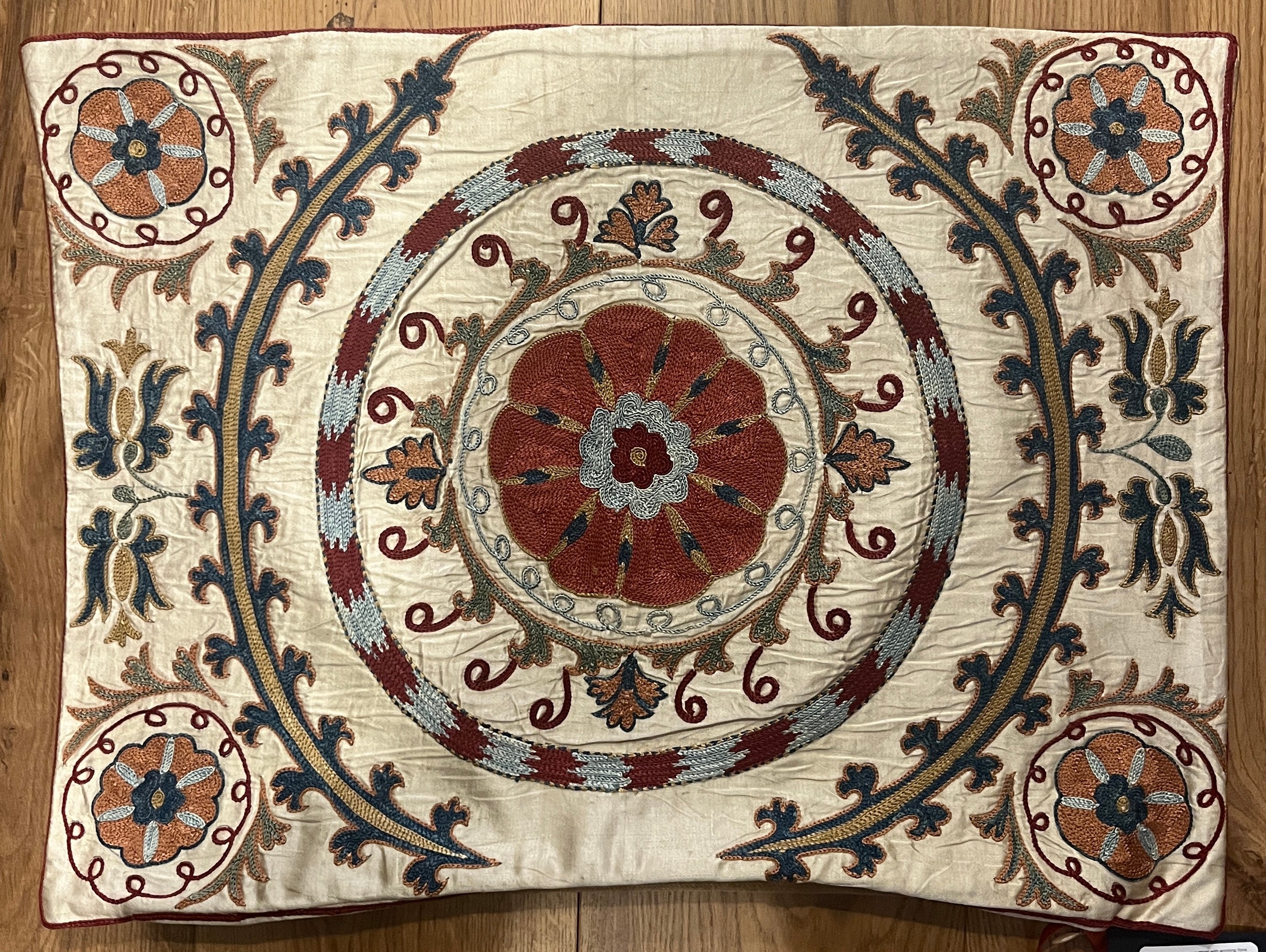 Rectangular silk suzani cushion with scrolling floral design and central medallion