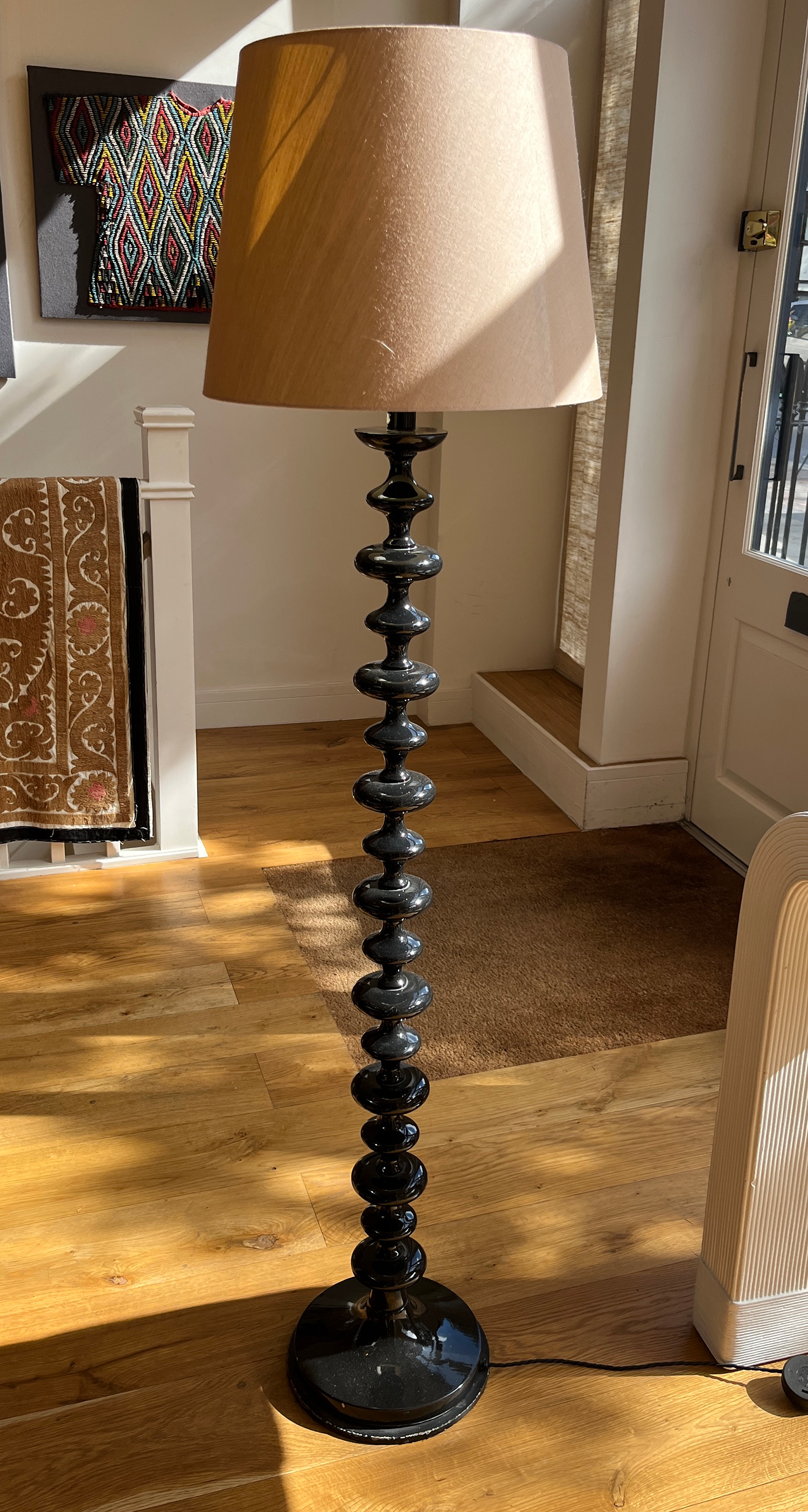 An ebonised tuned standard lamp on metal base